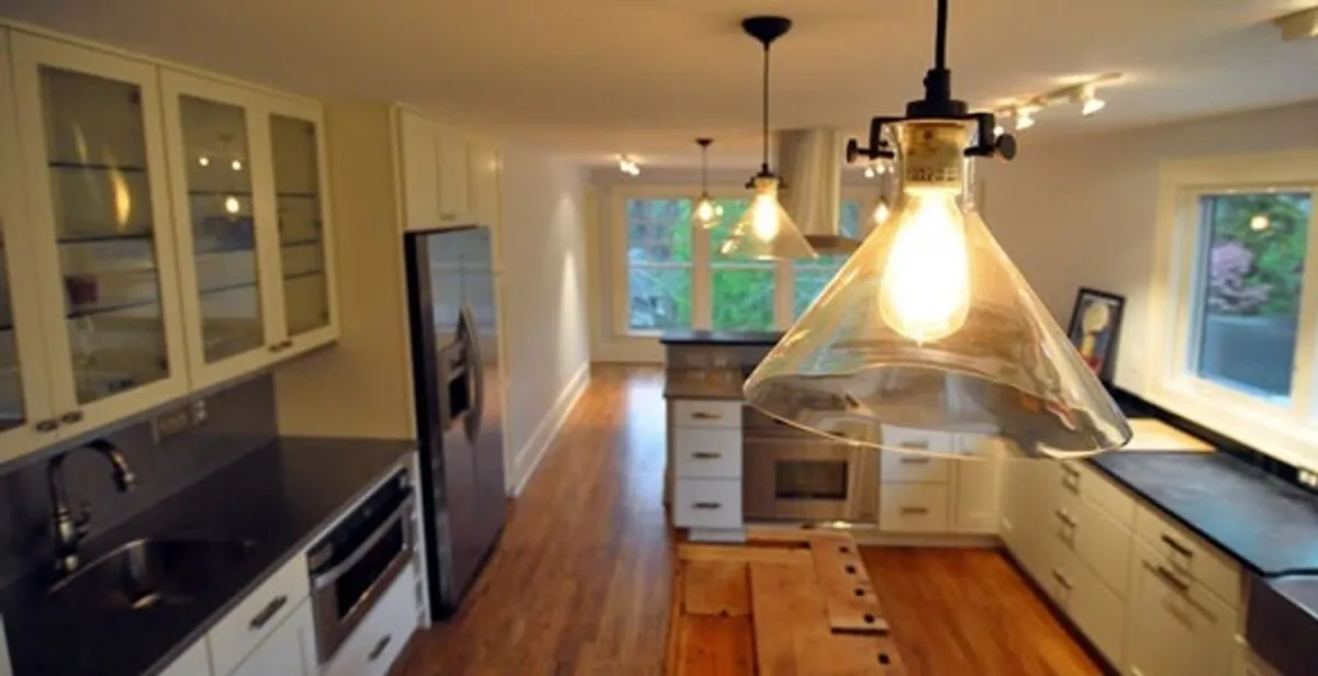 Residential electrician installing modern indoor light fixture in a home in Myrtle Beach, SC